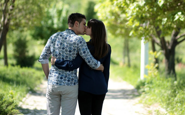 Una pareja se besa mientras pasea